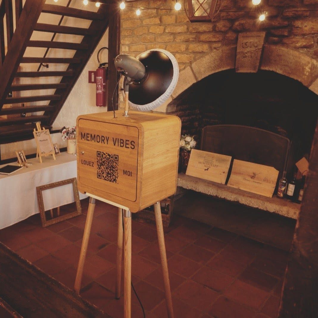 Photobooth en bois installé devant une cheminée ancienne